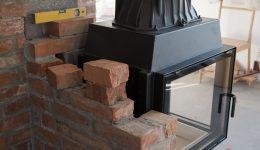 brick wall border for a wood-burning stove or fireplace under construction in the interior fitting area