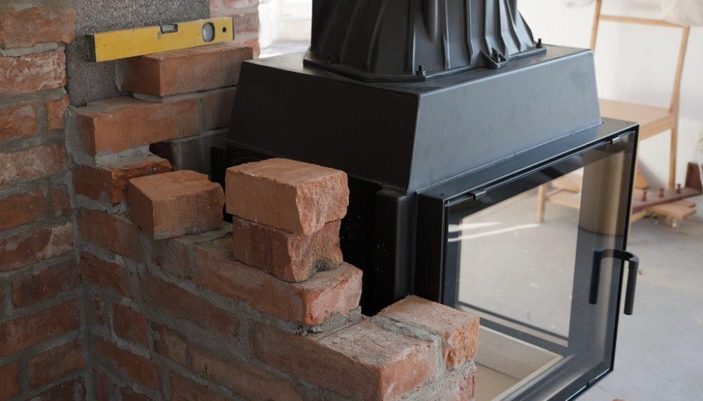 brick wall border for a wood-burning stove or fireplace under construction in the interior fitting area