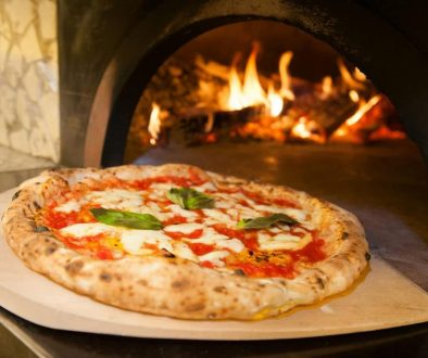 wyjmowanie pizzy z pieca opalanego drewnem